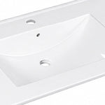 Close-up detail shot of white integrated ceramic vanity sink surface
