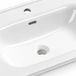 Glossy white ceramic sink interior close-up, featuring overflow slot, faucet hole and drain hole