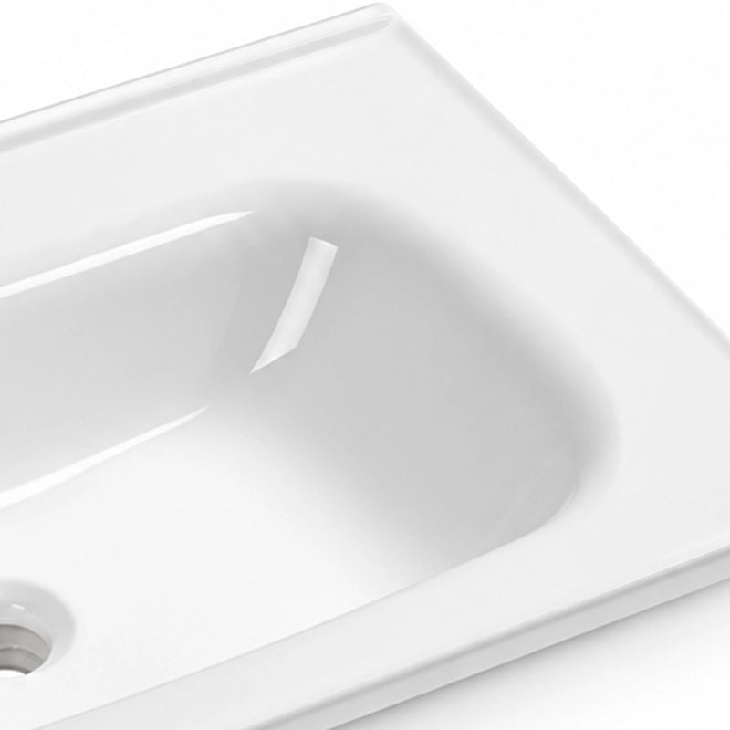 Glossy white ceramic vanity sink close-up, smooth curved basin surface with drain hole