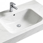 Close-up of Fish Maw White sintered stone wall-mount sink basin with chrome faucet and overflow hole