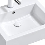 Close-up of glossy white rectangular ceramic semi-recessed sink basin with built-in overflow and drain