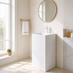 White square-basin freestanding bathroom sink positioned against a wall in a bright bathroom