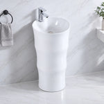 White ceramic oval pedestal bathroom sink with single-handle faucet in a modern bathroom