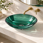 Green tempered glass round vessel bathroom sink with wall-mounted gold faucet on a marble countertop.