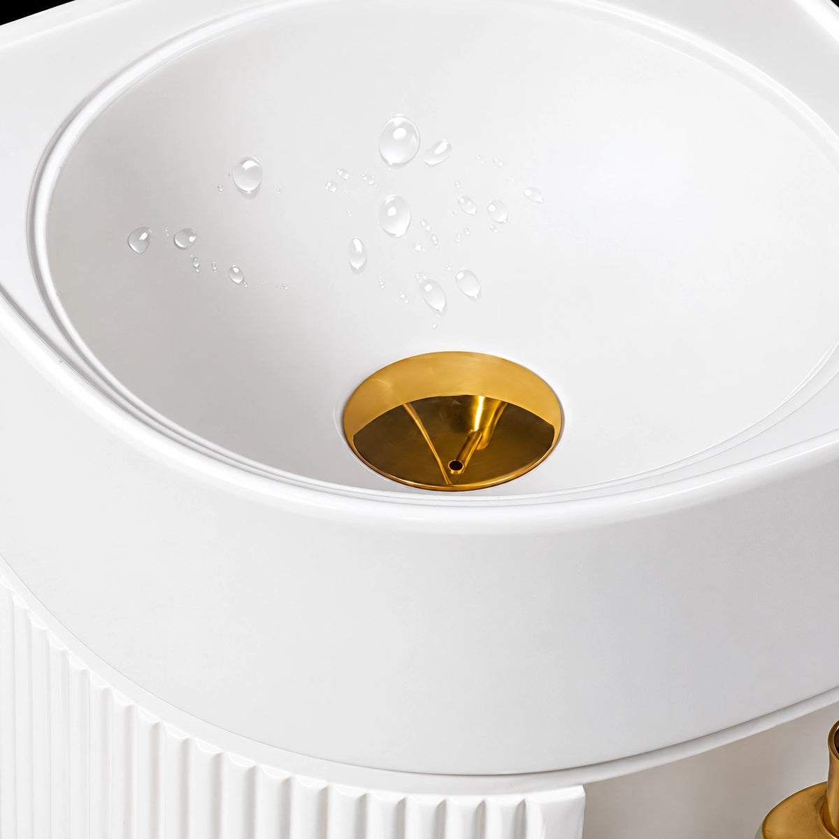White round bathroom sink basin with gold-tone drain assembly and water droplets