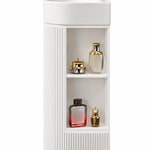 White freestanding bathroom sink with open storage shelves and vertical fluted cabinet design