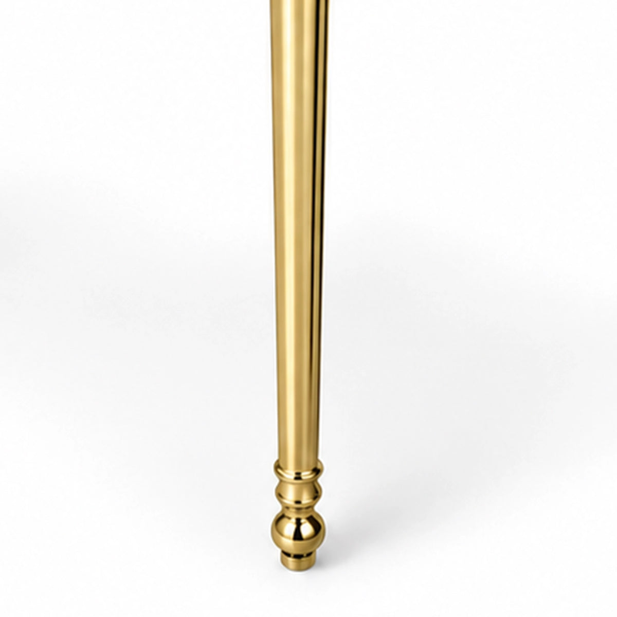 Close-up of a gold-tone console sink support leg with decorative detailing and rounded foot