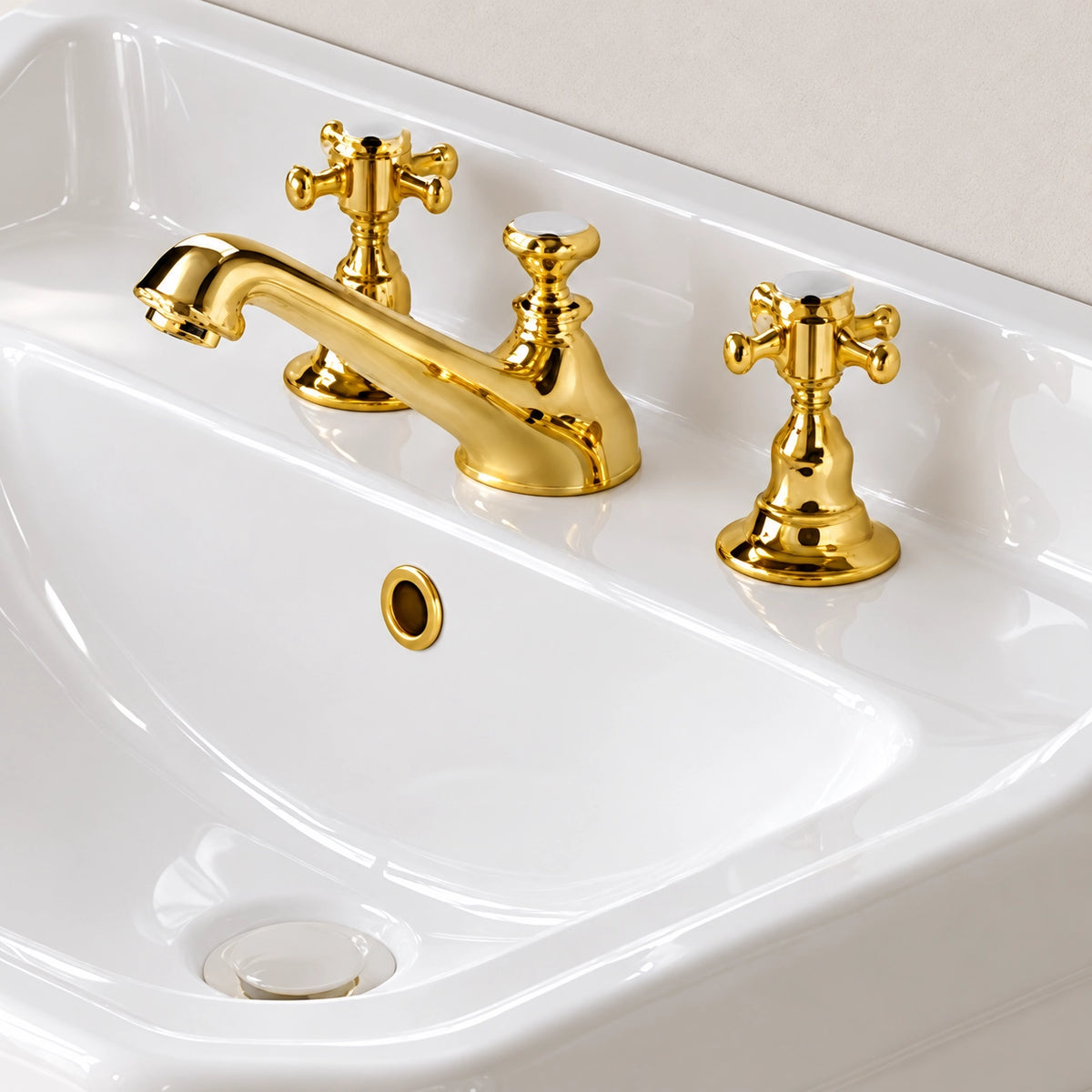 Close-up of white ceramic rectangular console bathroom sink with gold-tone three-hole faucet and overflow opening
