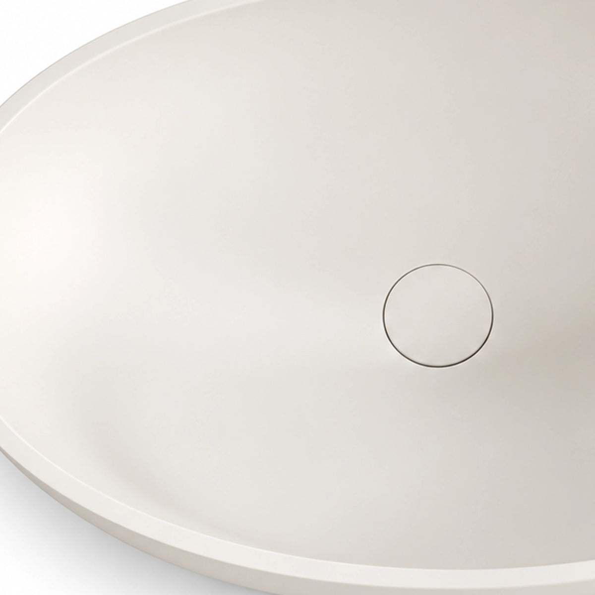 White engineered stone oval vessel bathroom sink with a close-up view of the drain opening