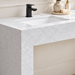 Close-up of a white engineered stone console bathroom sink with an integrated basin, black single-hole faucet, and marble-look finish.