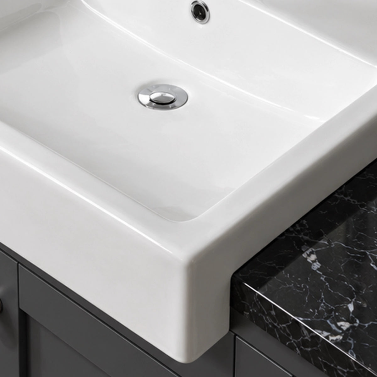 Close-up of white ceramic semi-recessed bathroom sink with smooth rectangular basin and raised front edge.