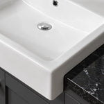 Close-up of white ceramic semi-recessed bathroom sink with smooth rectangular basin and raised front edge.