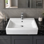 White ceramic semi-recessed bathroom sink with a rectangular basin, single-hole faucet, and integrated overflow on a modern vanity.